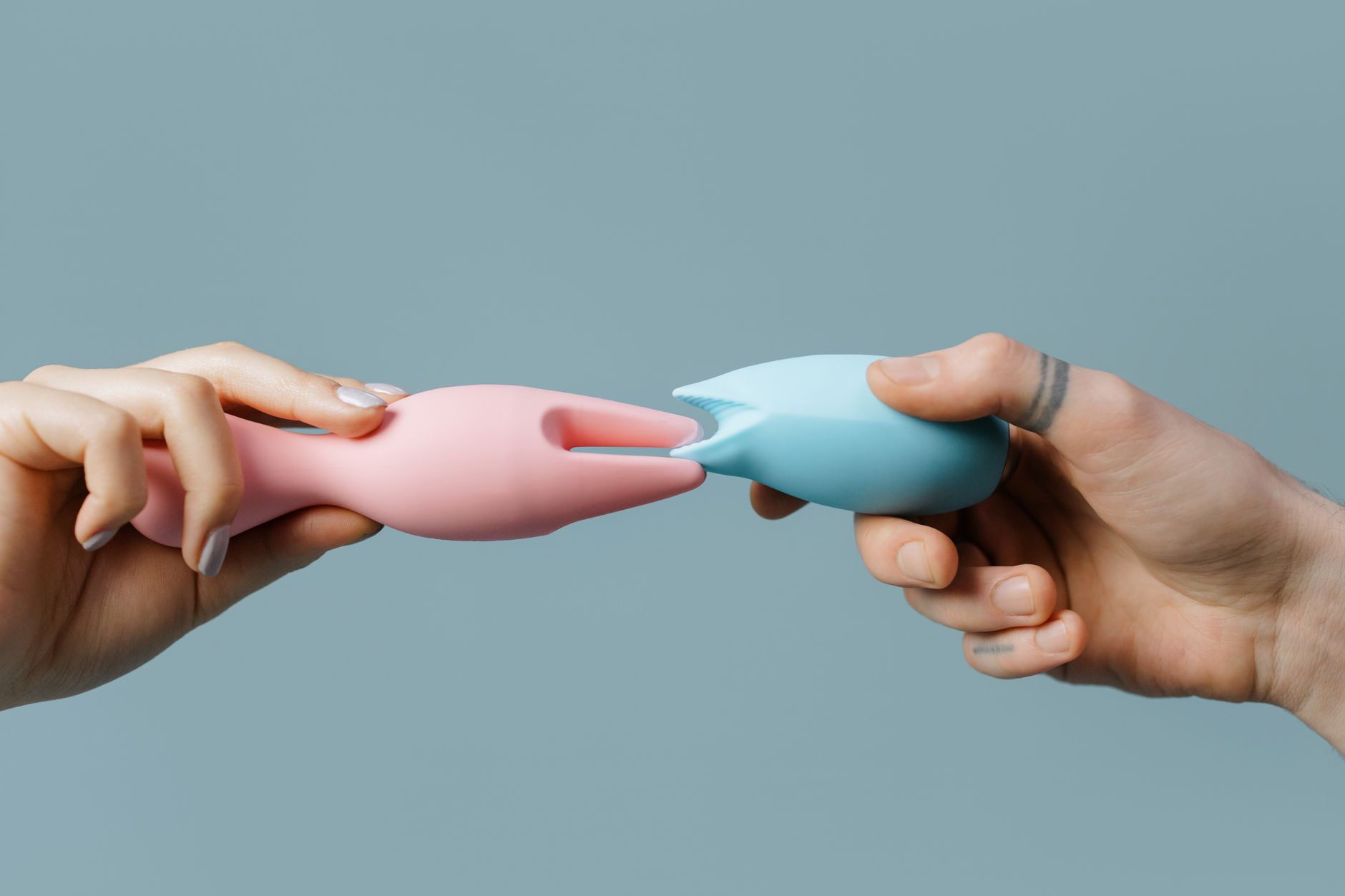 Mains tenant des jouets en silicone pastel, symbolisant la redécouverte du plaisir après une chirurgie