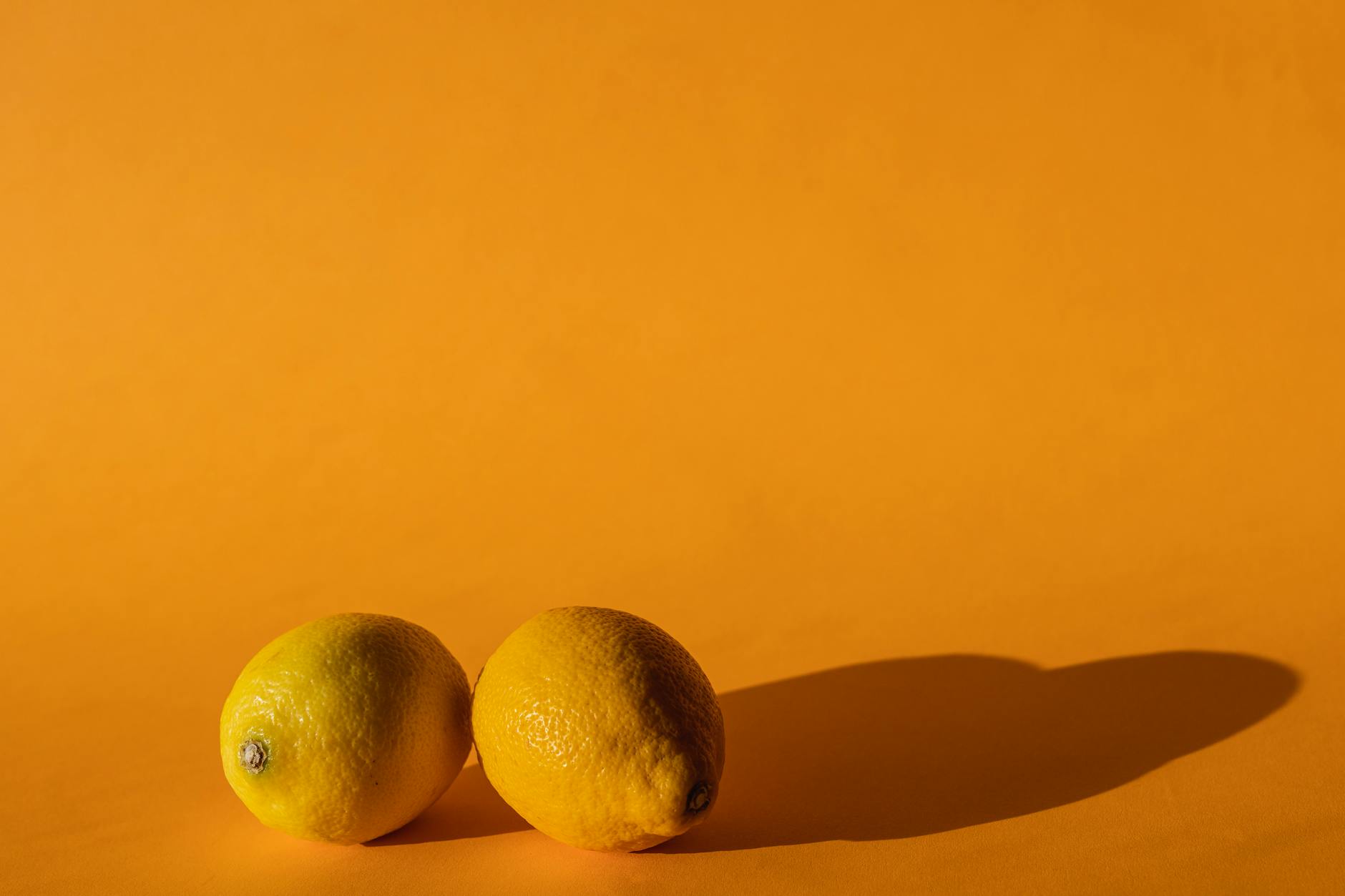 Citrons vivants disposés sur fond jaune lumineux en studio moderne