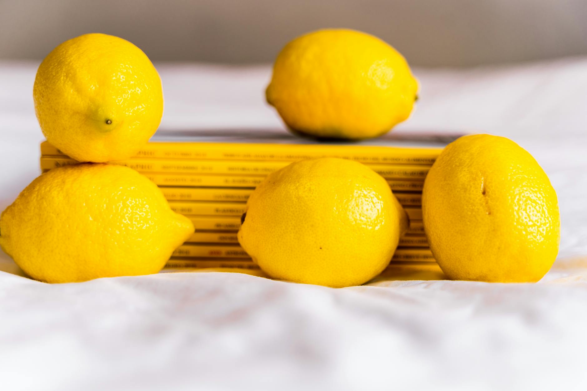 Une main tenant un vibromasseur citron contre un fond minimaliste pastel